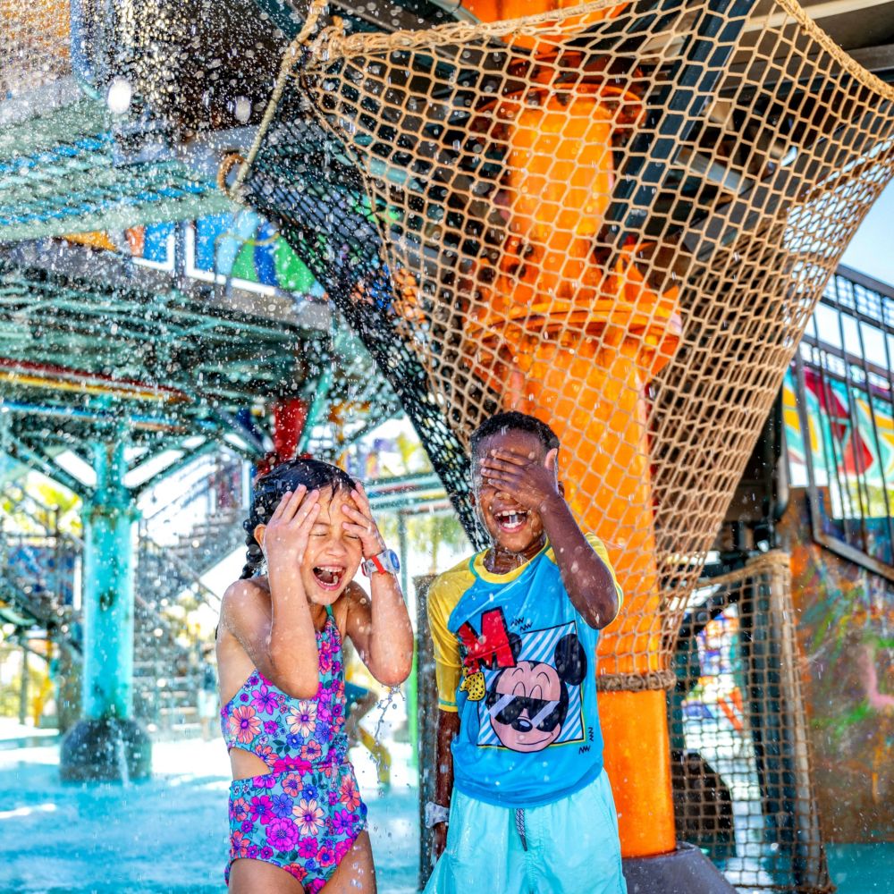 Deux enfants jouant dans l’aire de jeux aquatiques Rush Out Gush Out à Disney Lookout Cay, à Lighthouse Point
