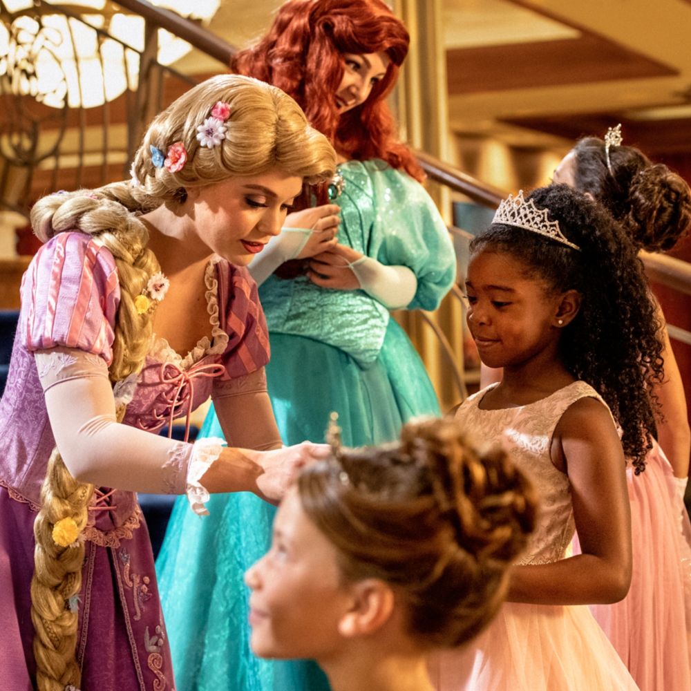 Des jeunes filles transformées en princesses à la boutique Bibbidi Bobbidi interagissant avec Cendrillon, Raiponce et Ariel
