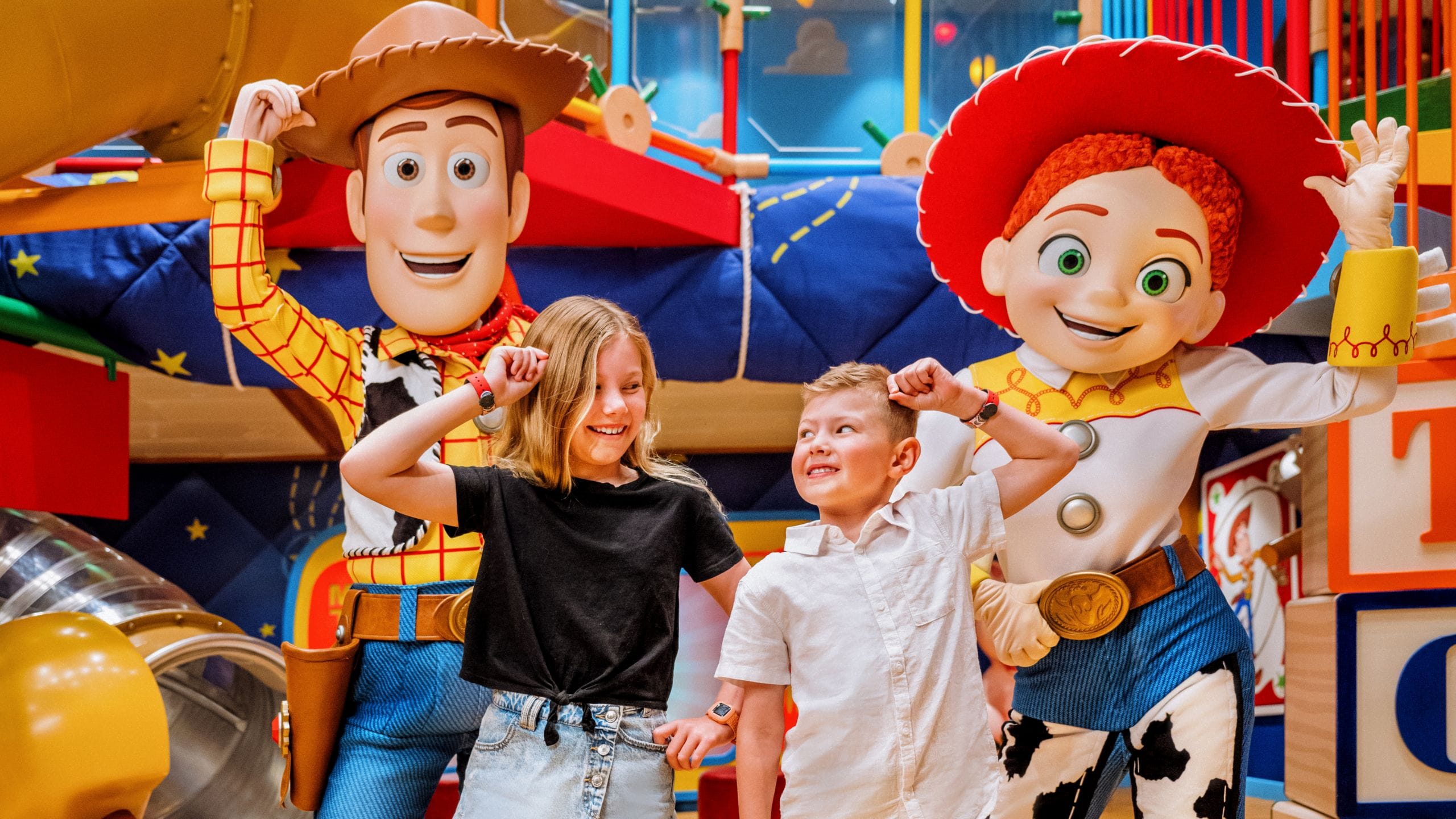 Duas crianças posando com Woody e Jessie no Andy's Room, no Disney's Oceaneer's Club