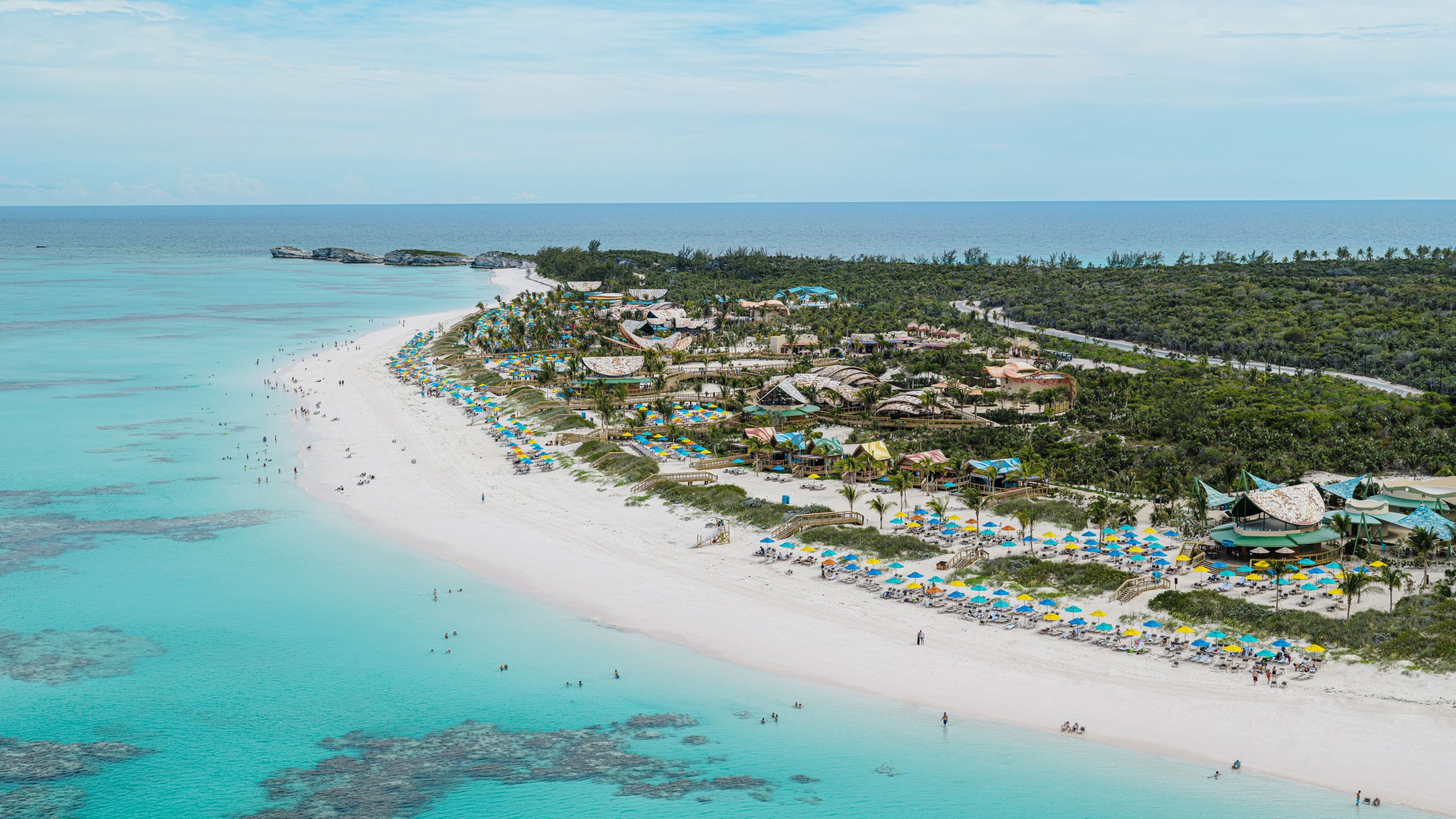 Guests playing in the surf and relaxing on the beach at Disney Lookout Cay at Lighthouse Point