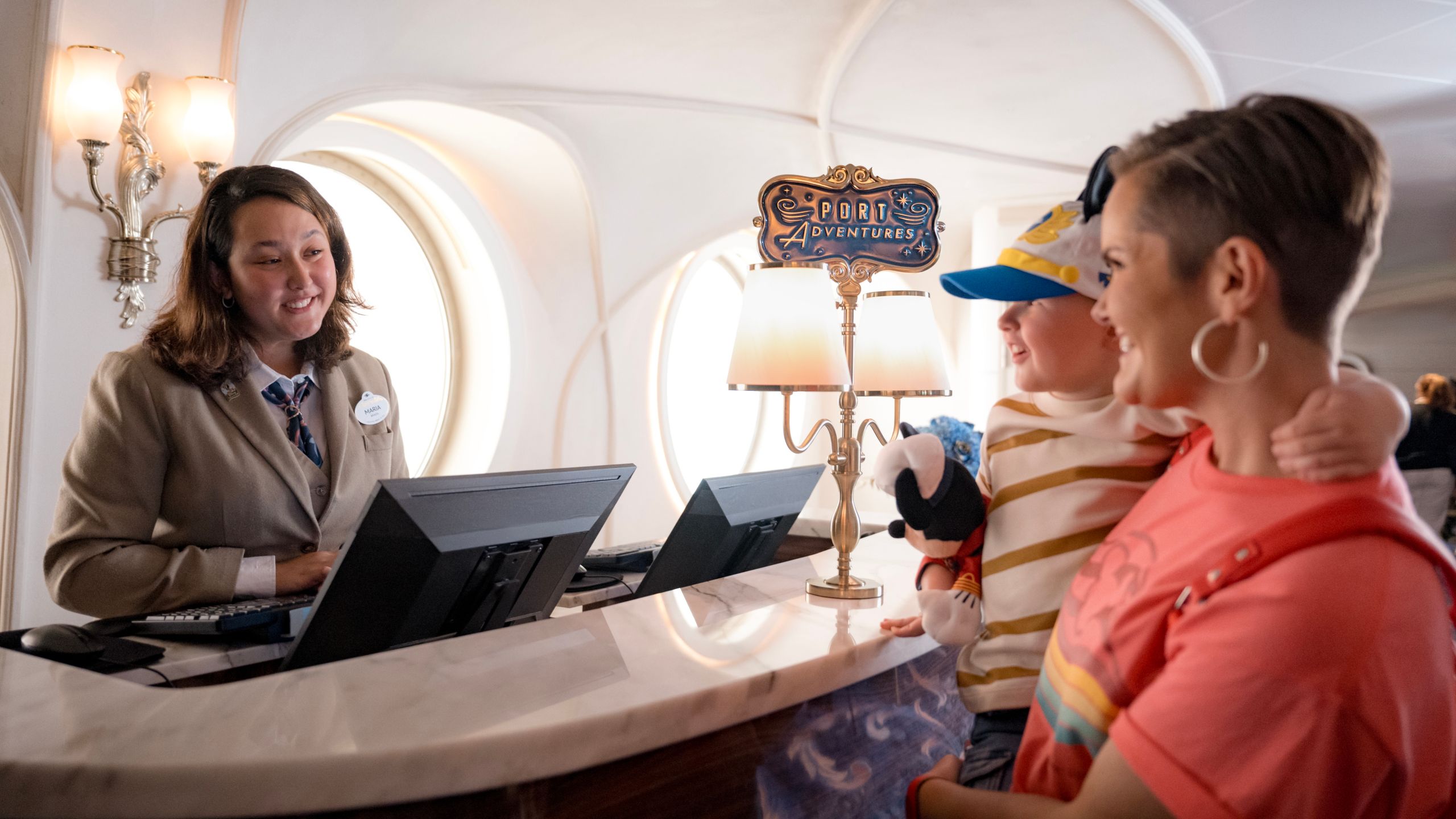 A Port Adventures Guide assisting the mother of a small child on board a Disney Cruise Line ship