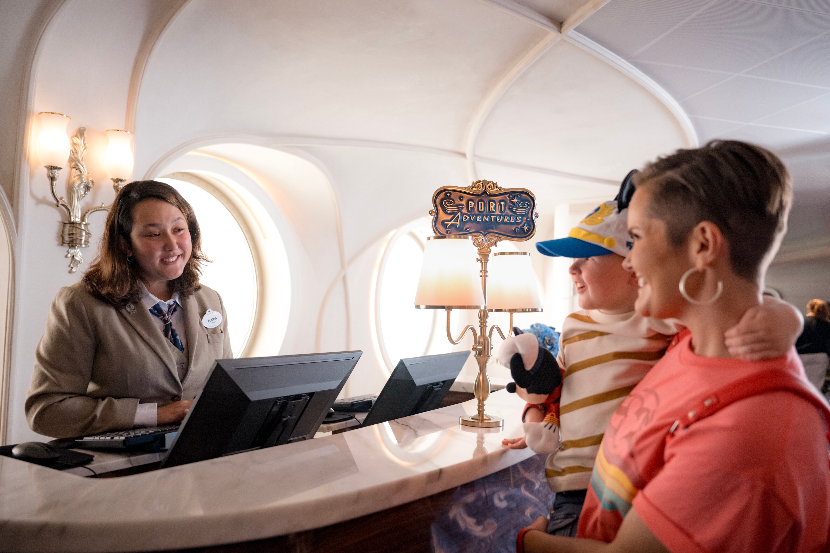 A Port Adventures Guide assisting the mother of a small child on board a Disney Cruise Line ship