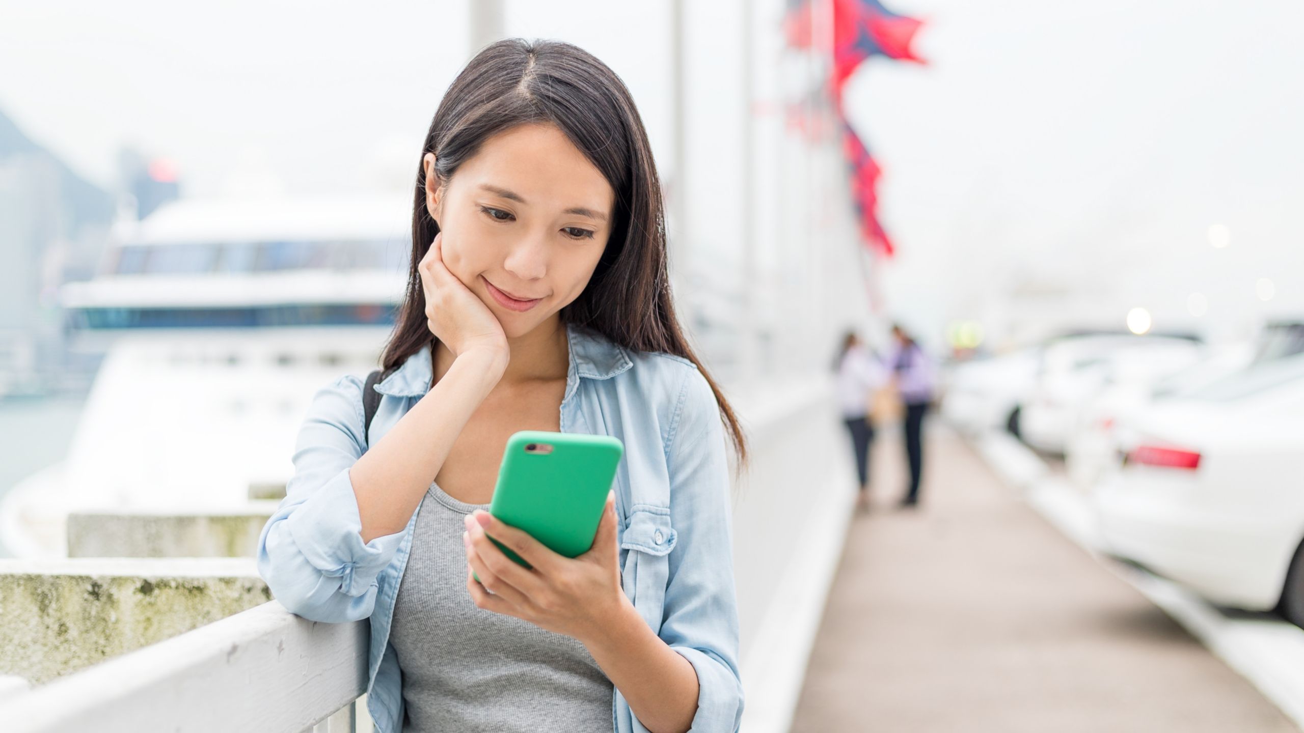 A woman looking at her smartphone at a cruise port