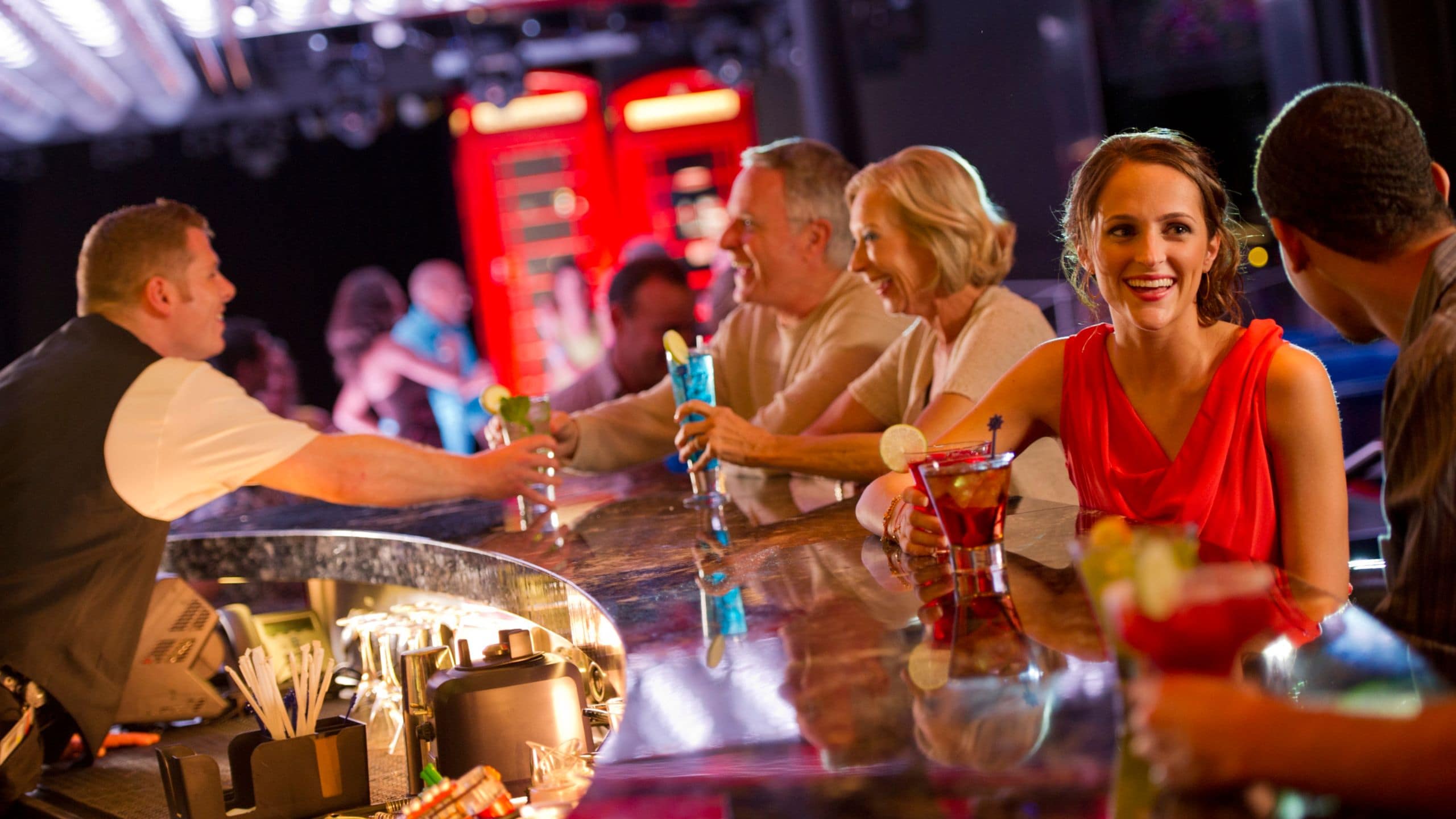 Hóspedes sentados e desfrutando de coquetéis na discoteca The Tube, a bordo do navio de cruzeiro Disney Fantasy