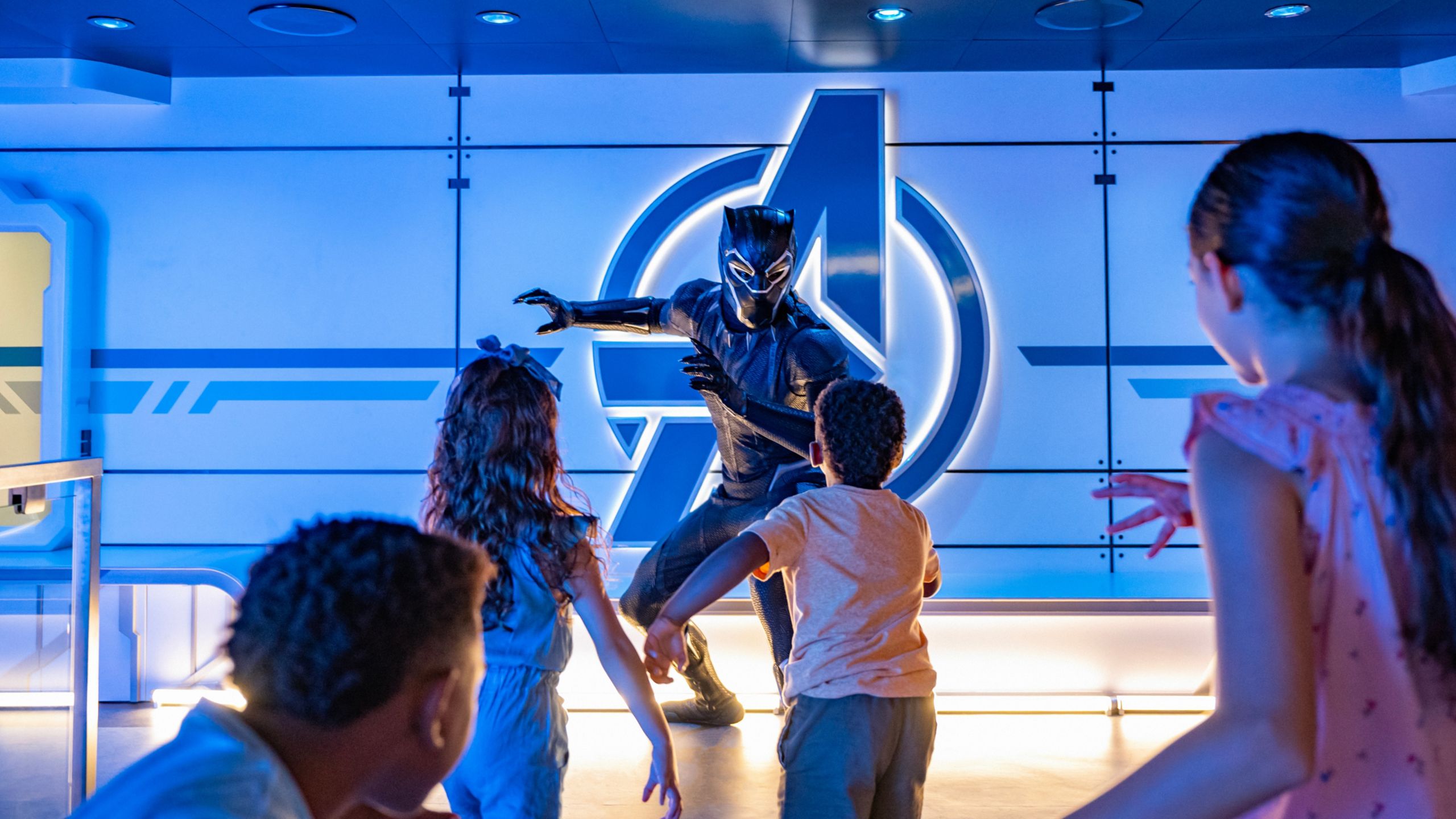 Black Panther crouching down while facing a group of Guests
