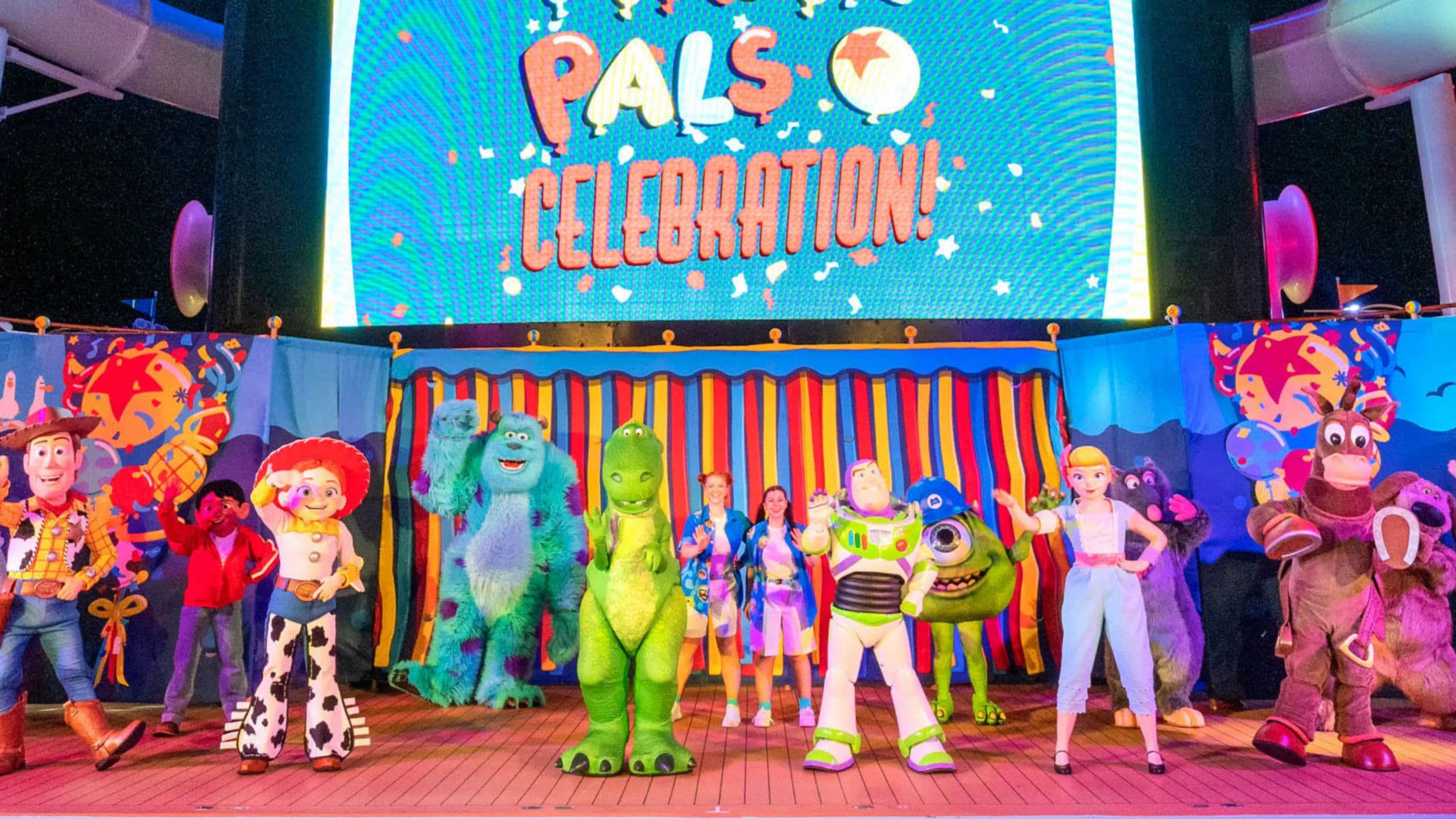 Pixar Characters waving on the deck of a Disney cruise ship with a screen that reads ‘Pixar Pals Celebration’