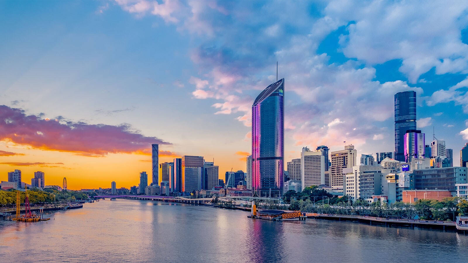 The Brisbane skyline features a river running through a city with tall buildings