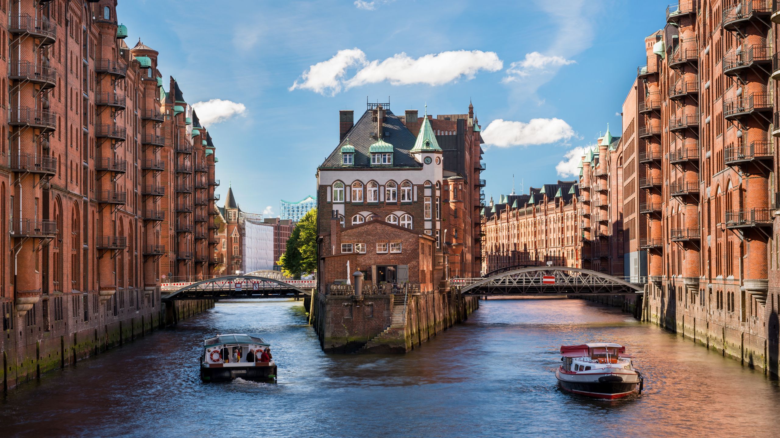 A moated castle with boats and historic buildings in Hamburg, Germany’s warehouse district. 