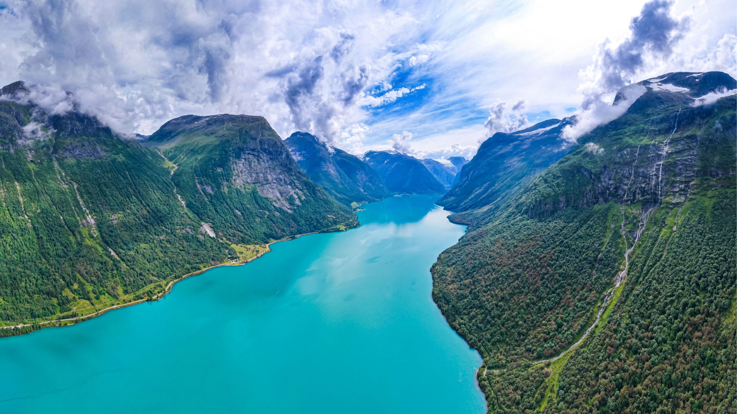 A fjord winding between steep, forested mountains