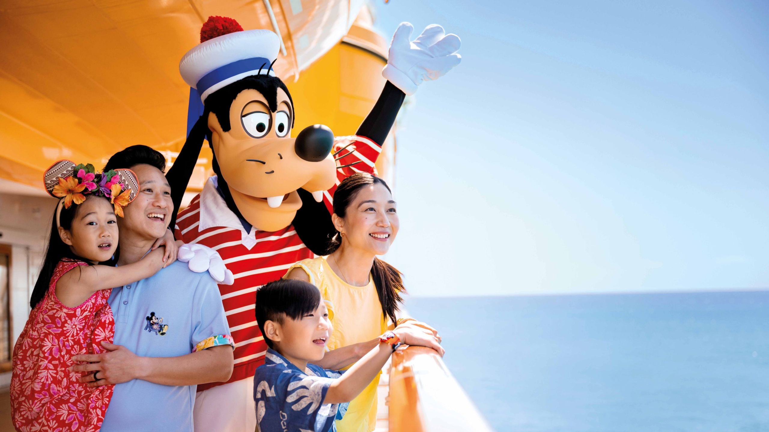 A family of 4 and Sailor Goofy standing at a ship’s railing and looking out to the sea