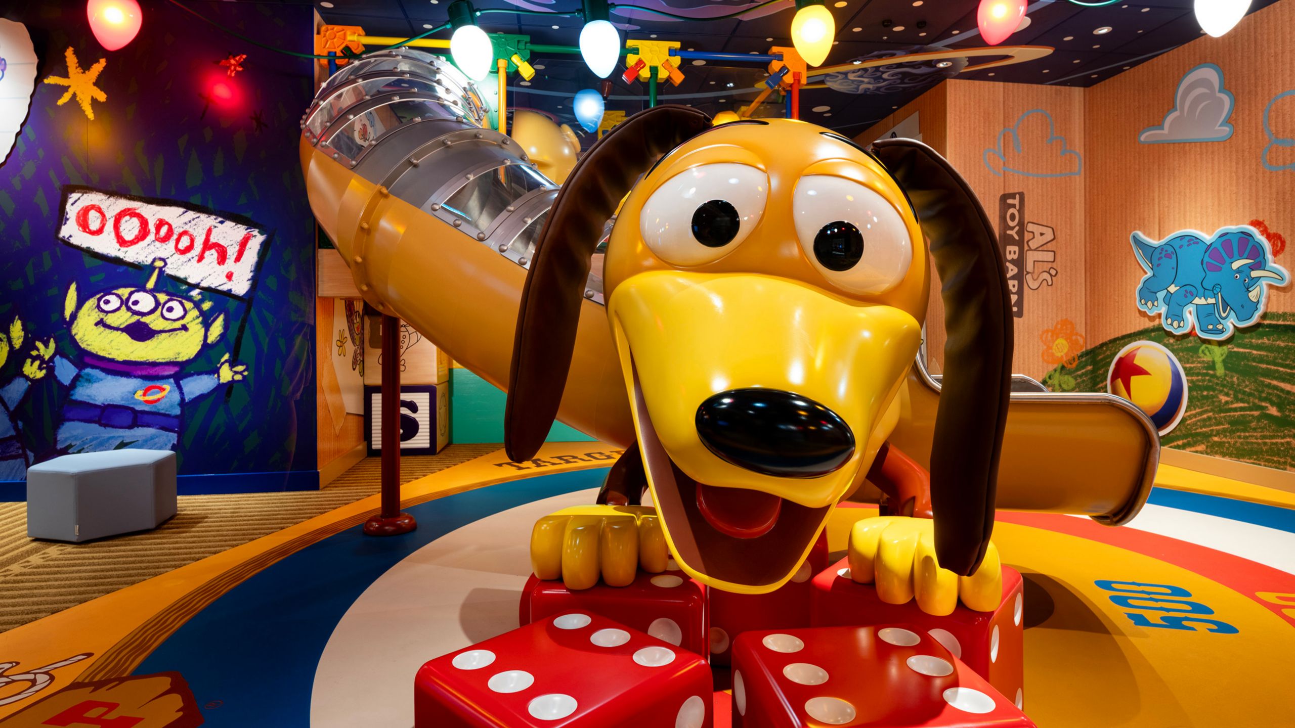 A Slinky Dog slide at Andy's Toy Box play area in the Disney’s Oceaneer Club, featuring giant dice and Toy Story murals