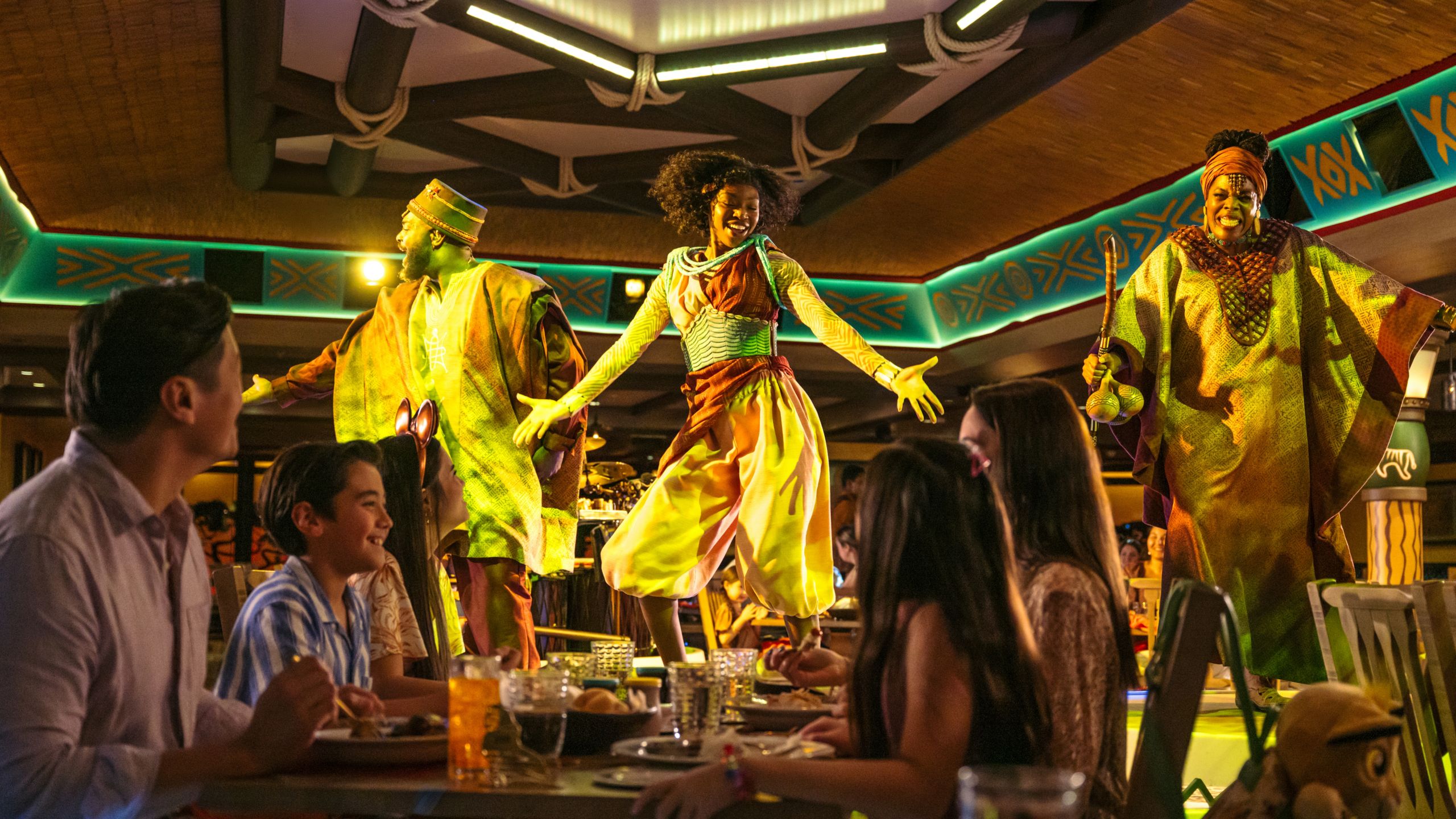 Huéspedes viendo una presentación de baile africano en Pride Lands: Feast of The Lion King a bordo del Disney Destiny