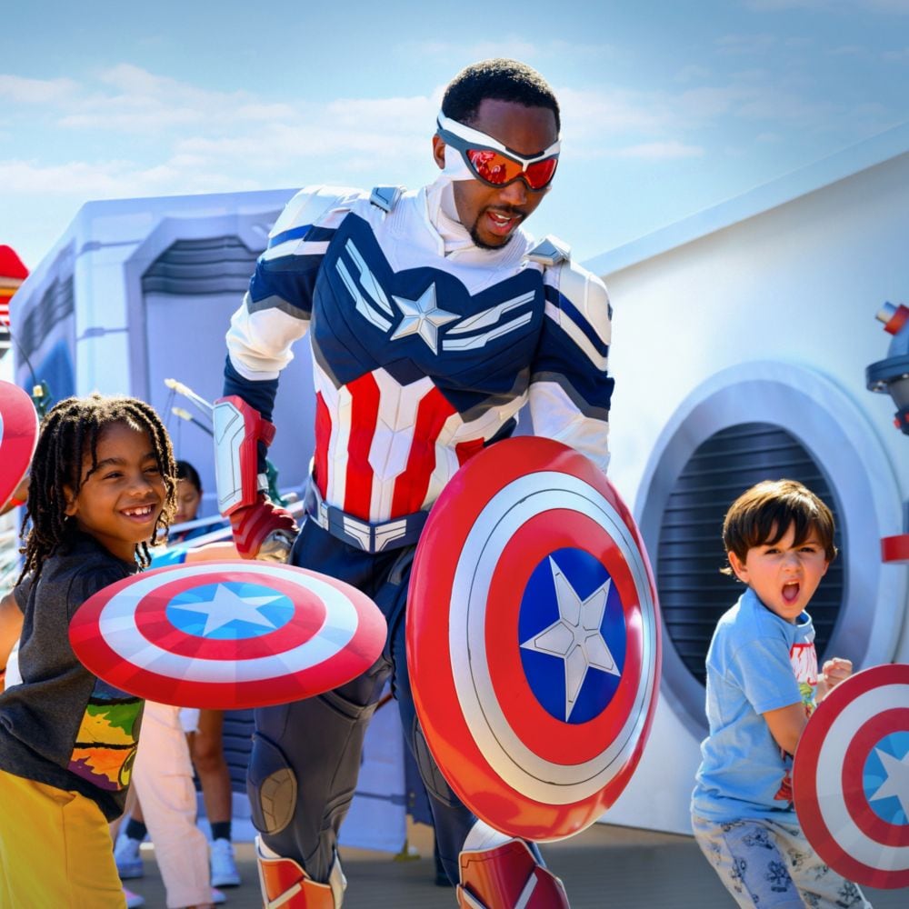 A group of children holding shields around Captain America Sam Wilson