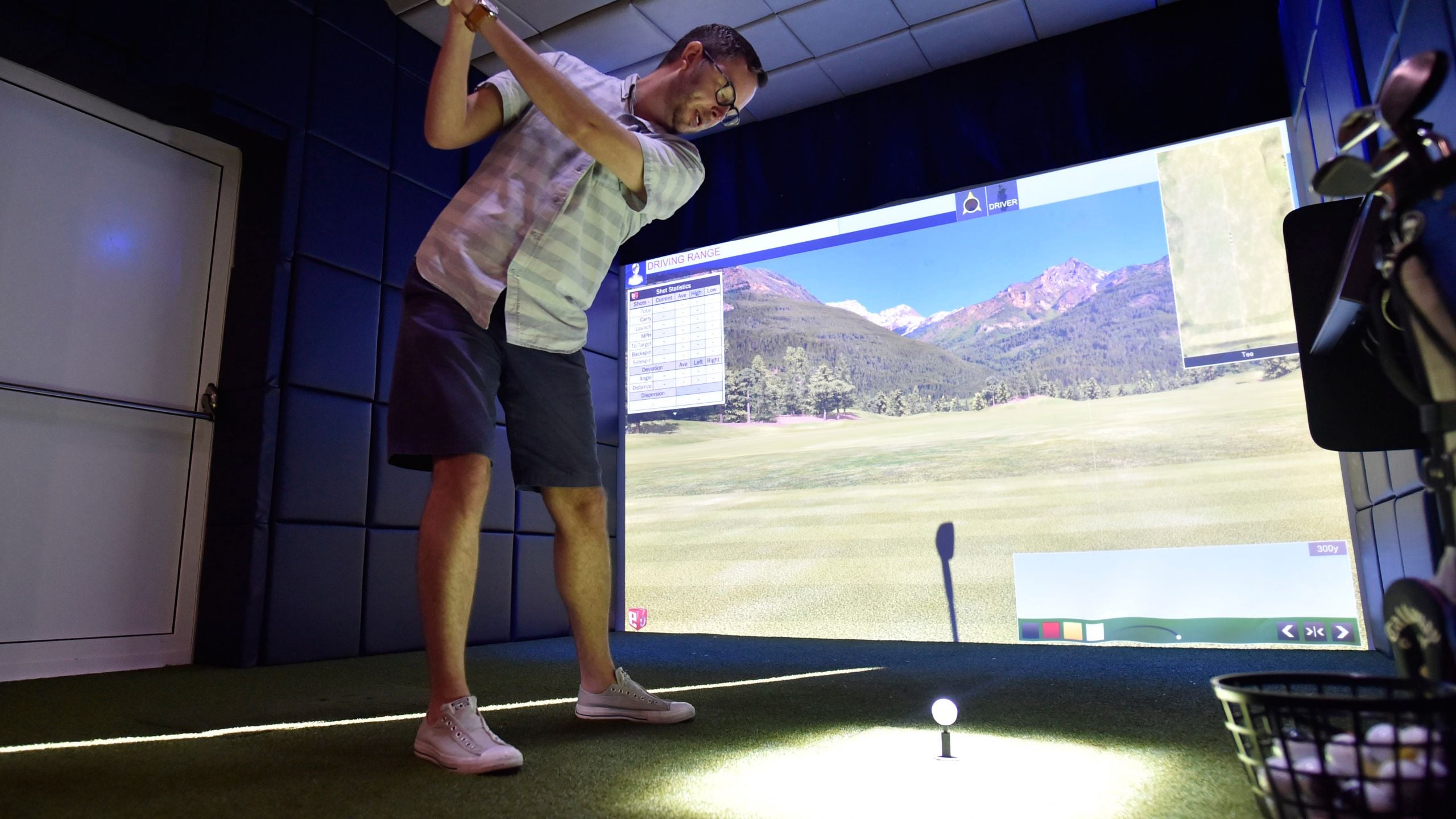 A man plays on a virtual golf simulator at Goofy's Sports Deck