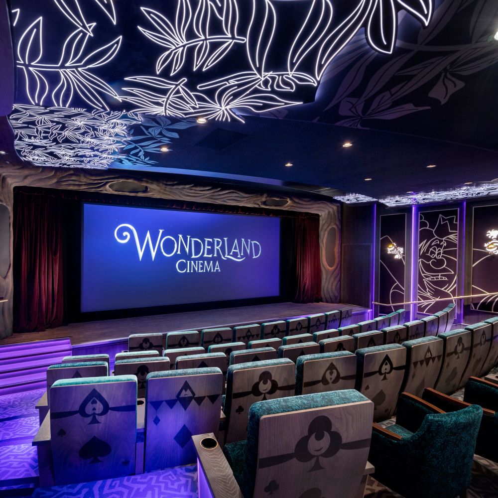 The Wonderland Cinema theater with a screen and chairs on the Disney Wish