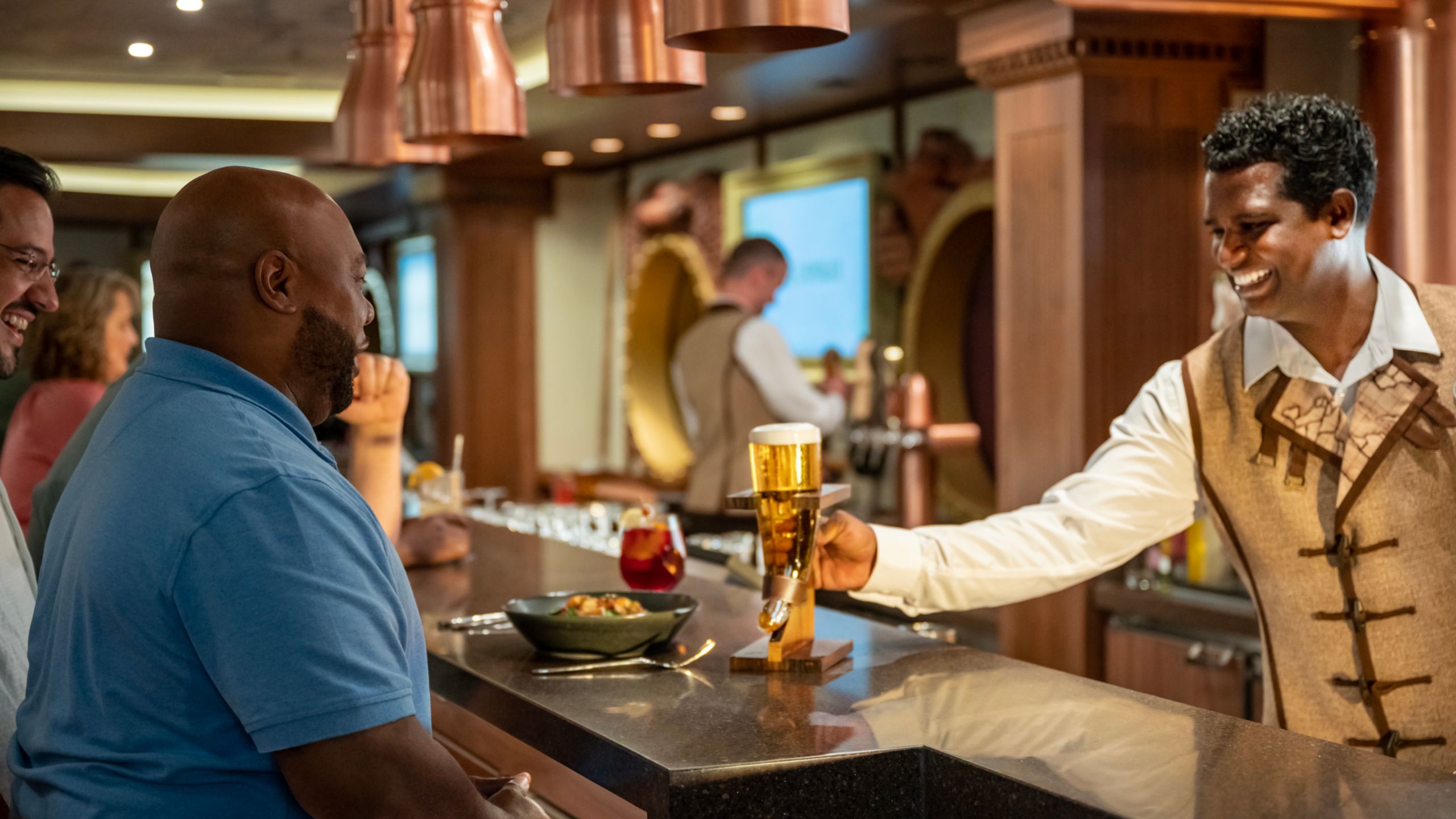 A Crew Member pouring a beer for a Guest at the Keg and Compass pub
