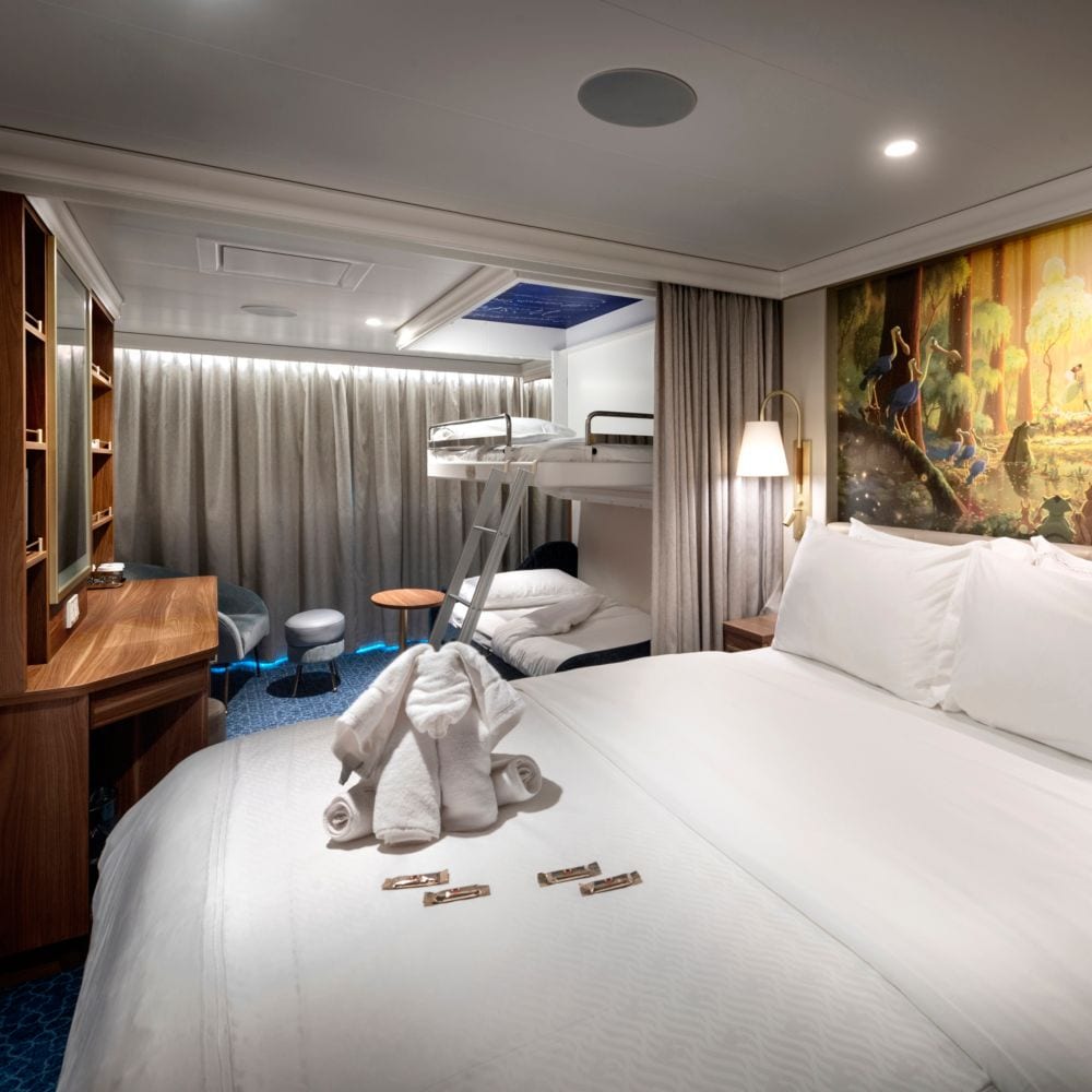A stateroom featuring The Princess and the Frog artwork and bunk beds that pull down from the ceiling