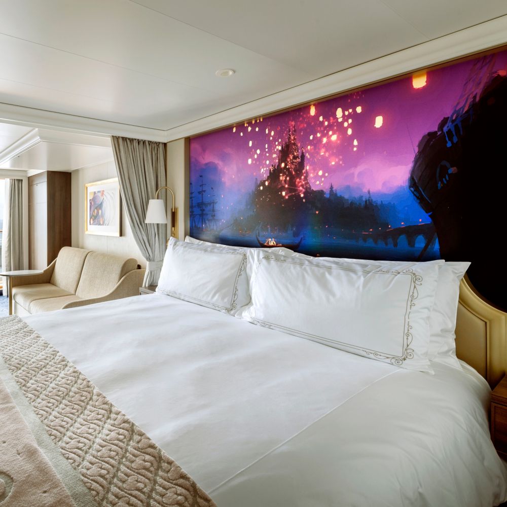 A stateroom featuring Tangled artwork over the bed and a connecting verandah