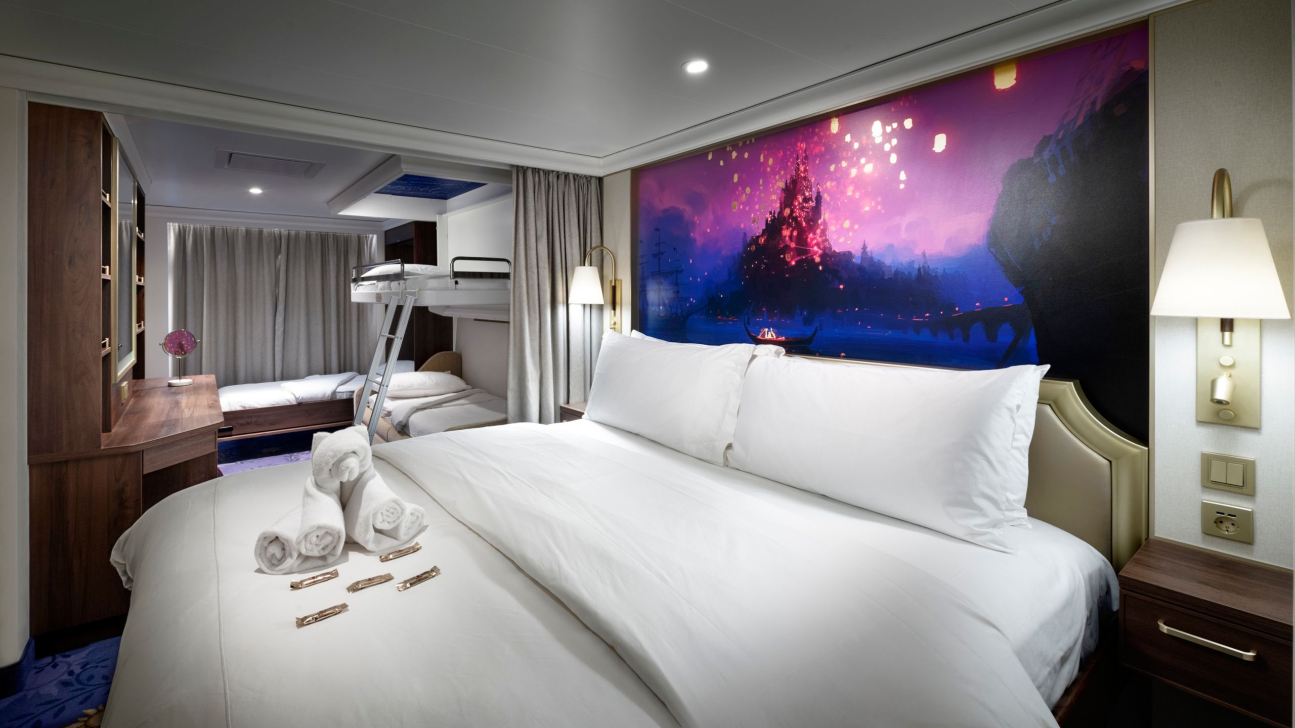 A stateroom featuring Tangled artwork and bunk beds that pull down from the ceiling