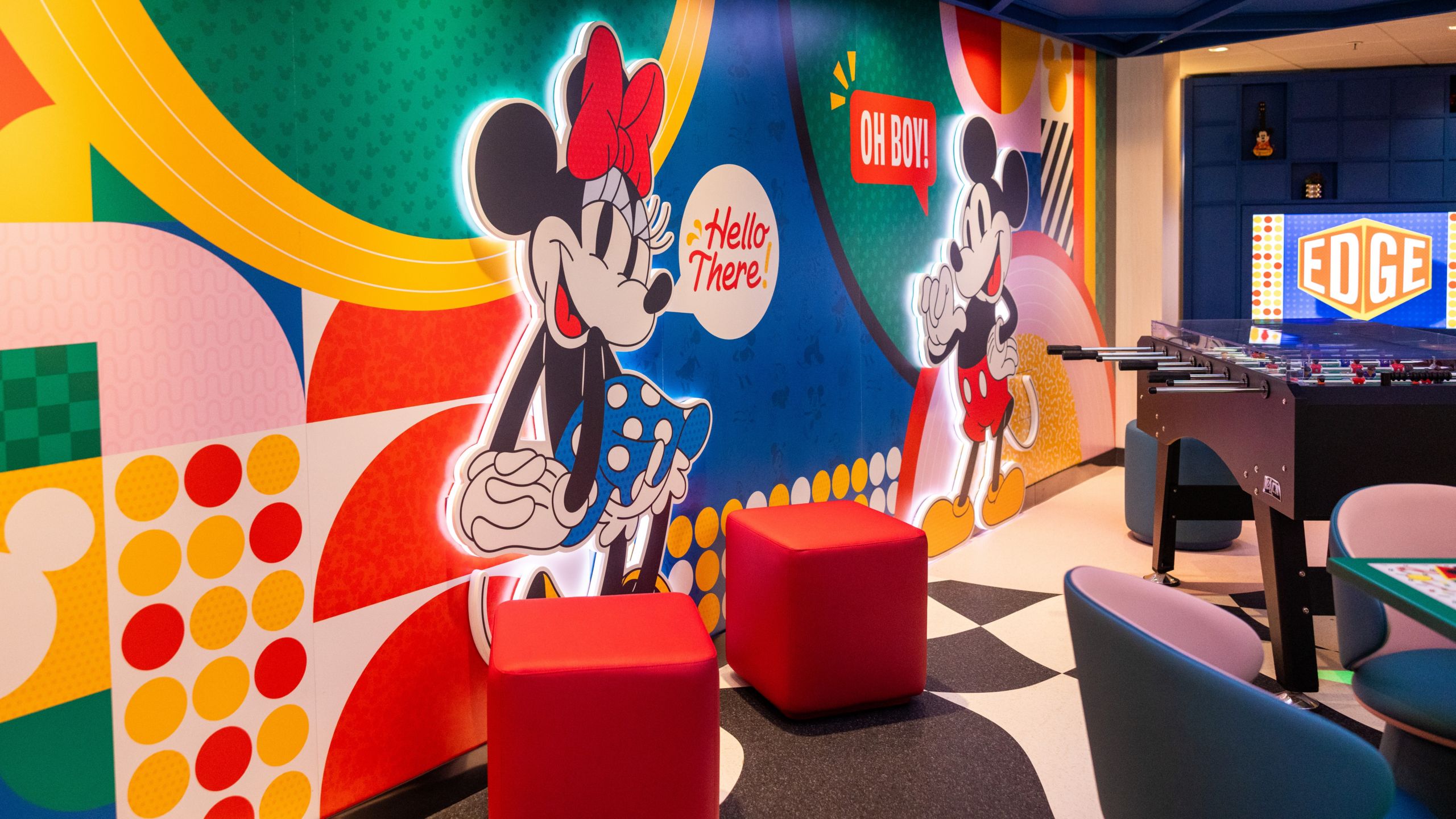 A foosball table beside a mural of Mickey Mouse and Minnie Mouse at Edge aboard the Disney Magic and Disney Wonder cruise ships