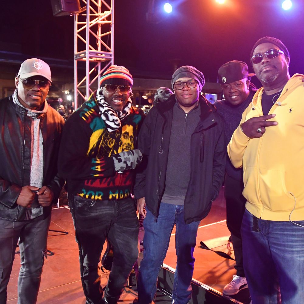 Five members of the Reggae Revival band standing on a stage