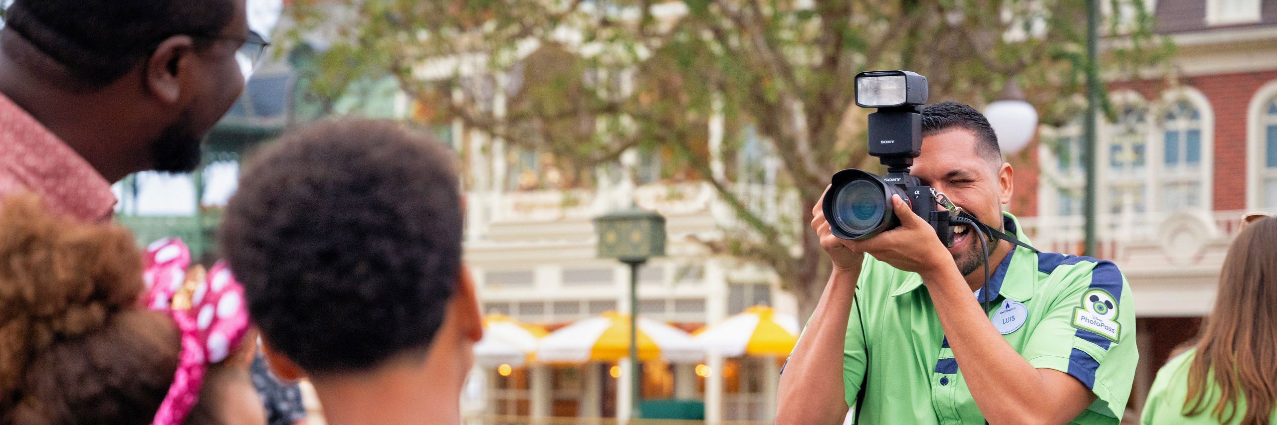 A Disney Cast Member taking a professional photo of a family